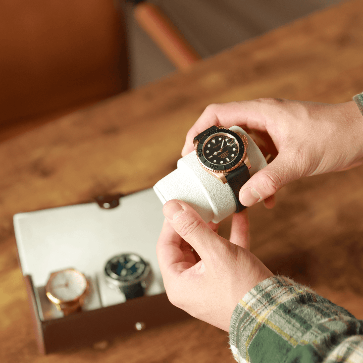 Person holding a watch with a white cushion from a vegan leather travel watch case.