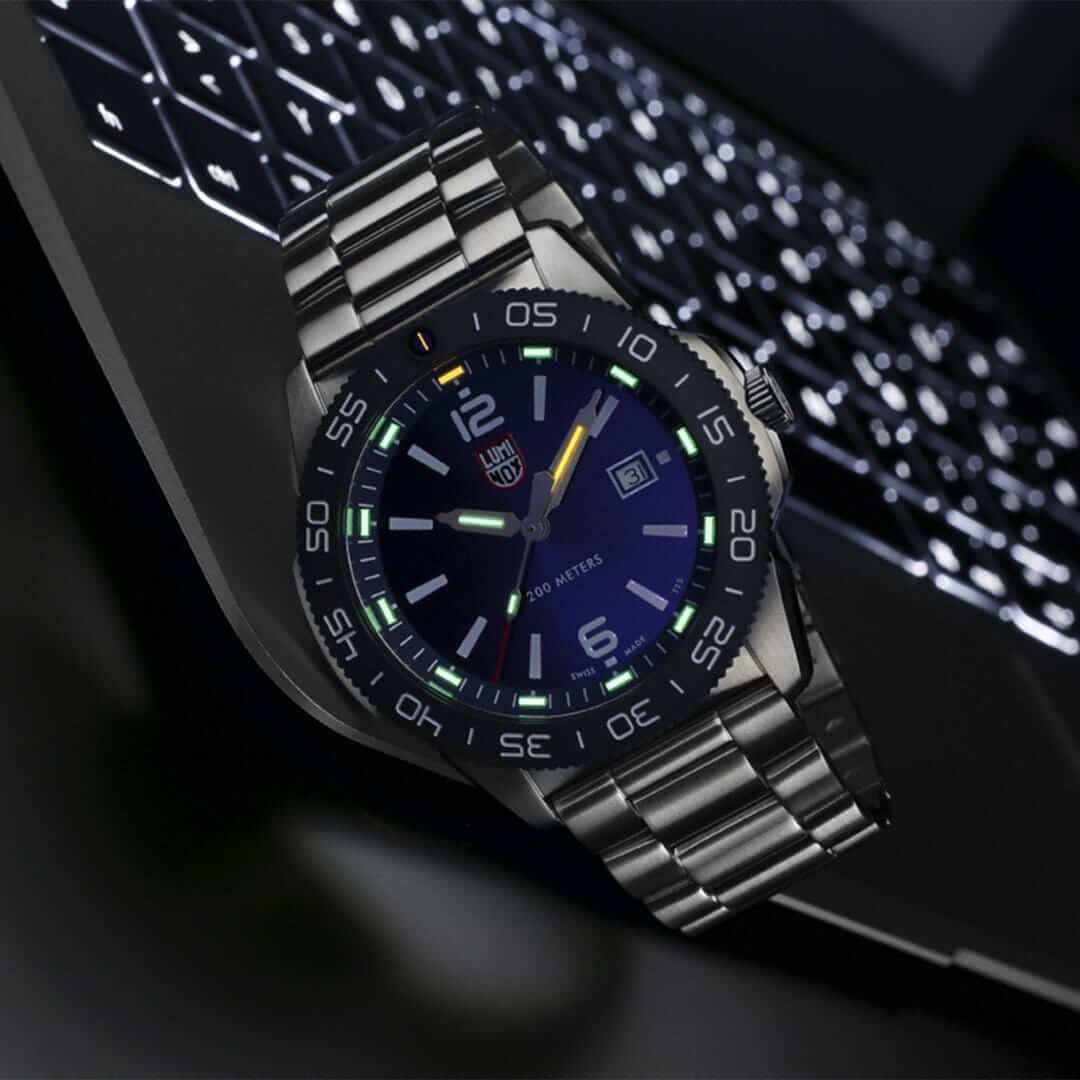 Luminox dive watch 44 mm on a laptop keyboard, featuring self-powered illumination and Swiss Quartz movement.