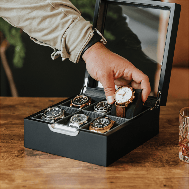 Modern watch storage box with six slots showcasing a hand placing a watch inside.