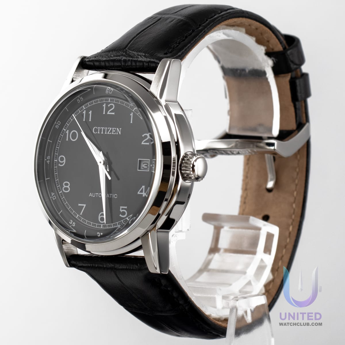 Citizen automatic black dial dress watch displayed with a stainless steel case and leather strap on a stand.